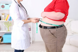 Doctor examining  patient obesity on light background